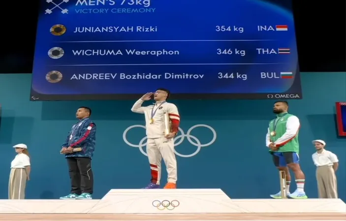 Lifter Rizki Juniansyah menyanyikan lagu kebangsaan Indonesia Raya usai pecahkan rekor Olimpiade Paris. /Tangkap layar instagram/@vidiosport/